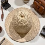 Handwoven straw hat with vintage camera, wide brim beach accessory, natural beige herringbone weave
