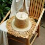 Top view handwoven straw garden hat with natural fringe, spiral crown pattern, wide brim boho design