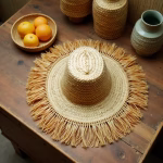 Overhead view of handwoven garden hat with fringe on rustic table