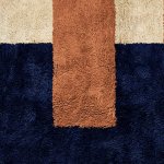 Close-up of plush boho rug showing rich navy and terracotta pile texture with color block pattern detail