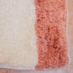 Close-up of coral accent and cream texture on Moroccan boheme rug