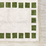 Corner detail of handcrafted Moroccan wool rug with cream and green geometric pattern