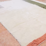 Detail of cream and coral sections on handwoven boheme wool rug