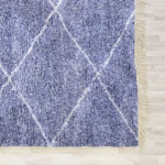Detail of diamond lattice pattern and edge fringe on handmade blue farmhouse rug