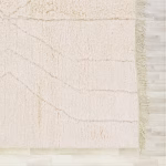 Edge detail of handmade boho Moroccan rug showing delicate fringe and textural pattern