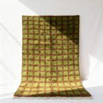 Green and brown handcrafted Moroccan trellis rug with geometric square motifs