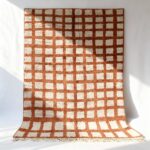 White and rust terracotta Moroccan trellis rug featuring hand-stamped grid pattern