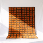 Handmade Moroccan trellis rug with vibrant orange squares on brown grid pattern