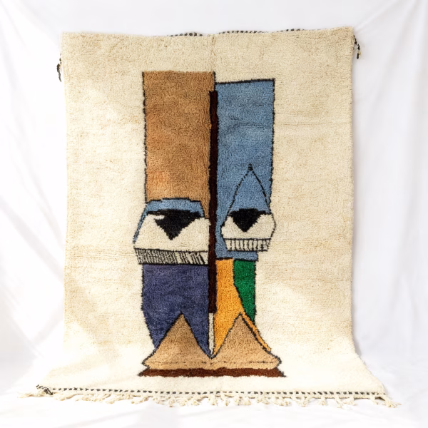 Handwoven Berber rug with abstract face design in cream, blue, and gold tones
