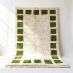 Handwoven Moroccan wool rug with cream center and emerald green square border pattern