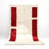Handwoven Moroccan wool rug with vertical red rectangles and natural fringe