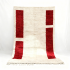 Handwoven Moroccan wool rug with vertical red rectangles and natural fringe