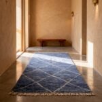 Sky blue farmhouse wool rug with traditional diamond motifs displayed in warm Moroccan-style interior hallway