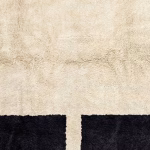 Minimalist Moroccan wool rug with black border details on natural background