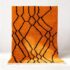 Handwoven Moroccan rug with vibrant orange wool and bold black geometric diamond pattern with white fringe trim