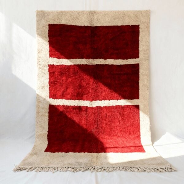 Red handwoven Moroccan area rug with three horizontal cream stripes on beige border, minimalist grid design