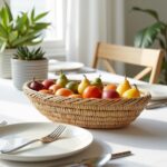 Natural straw kitchenware 14" oval basket holding colorful pears and fruit on white dining table setting