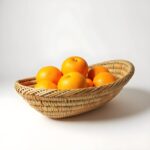 Handwoven straw kitchenware 14" oval basket with oranges, natural honey-beige tone, Moroccan craftsmanship