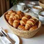 Straw kitchenware 14" oval basket holding fresh croissants, natural woven texture for bread service display