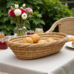 Natural straw kitchenware 14" oval basket with bread rolls on outdoor table, handwoven Moroccan design