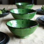 Green glazed ceramic clay bowl with natural speckled finish and decorative scalloped edge, handmade pottery detail