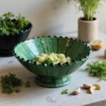 Bottom view of handmade green ceramic pottery bowl showing artisan glaze and pedestal base