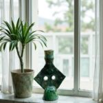 Tamegroute green ceramic candlestick on windowsill with plant, featuring artisan glazed finish