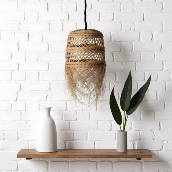 Handmade straw hanging light against white brick wall with wooden shelf