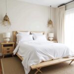 Bell-shaped handwoven straw pendant lights above bed creating warm ambient bedroom lighting