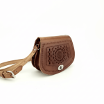 Handcrafted embossed leather crossbody bag side view showing saddle shape and adjustable natural leather strap