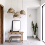 Trio of straw chandeliers creating visual interest in bright white room
