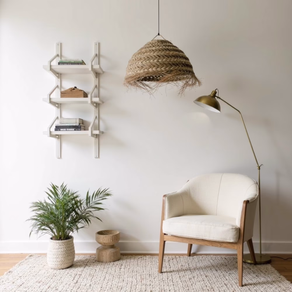 Handwoven straw pendant light above cream accent chair in minimalist corner
