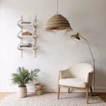 Handwoven straw pendant light above cream accent chair in minimalist corner