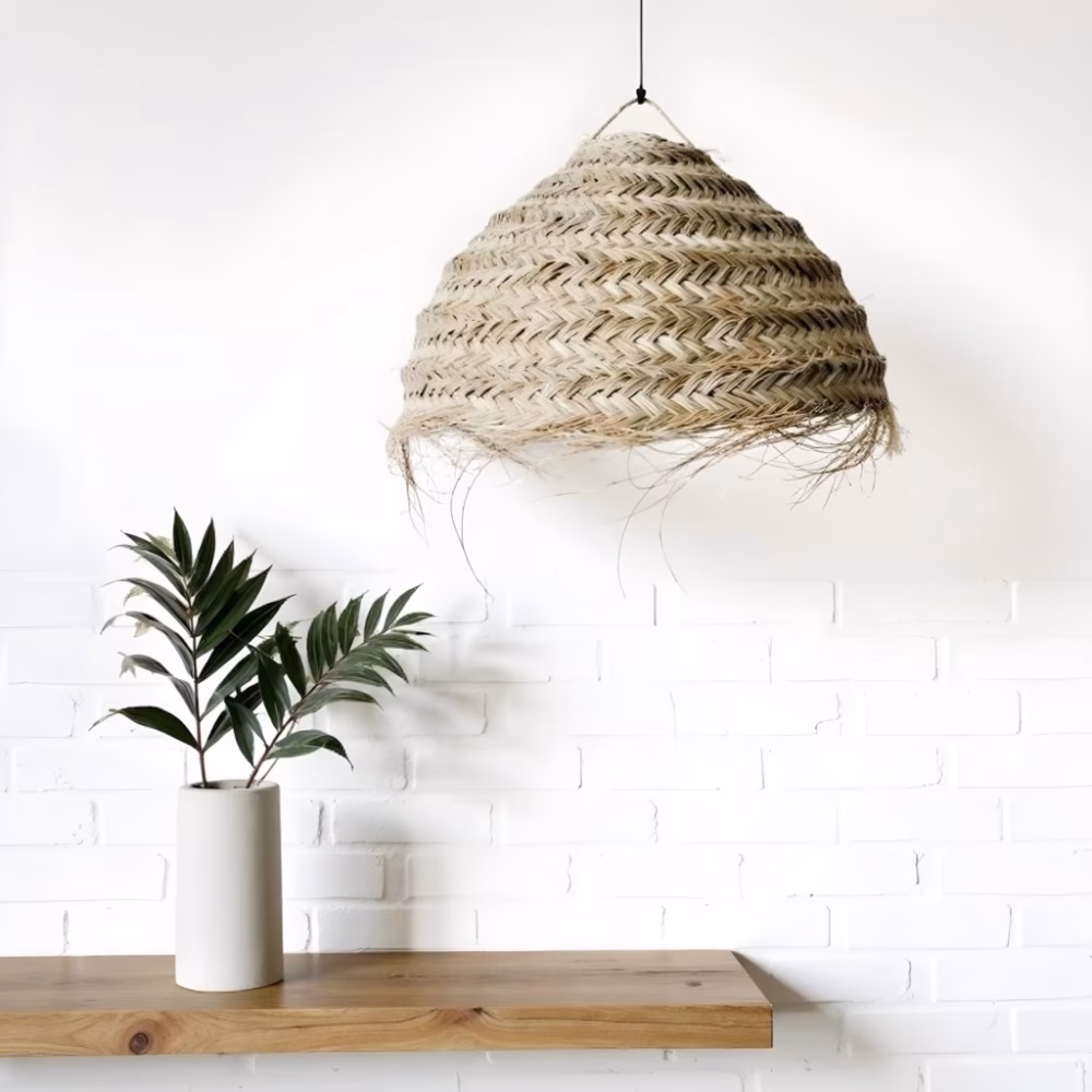 Close-up of handwoven straw chandelier showing intricate natural fiber pattern against white brick wall