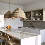 Row of handwoven straw pendant lights illuminating modern kitchen island