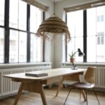 Natural handwoven straw chandelier with herringbone pattern illuminating minimalist home office workspace