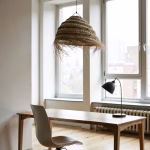Handmade straw pendant light above wooden desk in minimalist home office