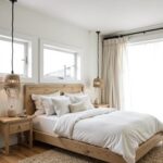 Handwoven straw pendant light in modern bedroom with natural wood furniture and white bedding