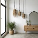 Three handwoven straw pendant lights with bohemian fringe detail in minimalist entryway with wood console