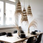 Multiple handwoven straw pendant lights creating dramatic cascade in modern stairwell with wood steps