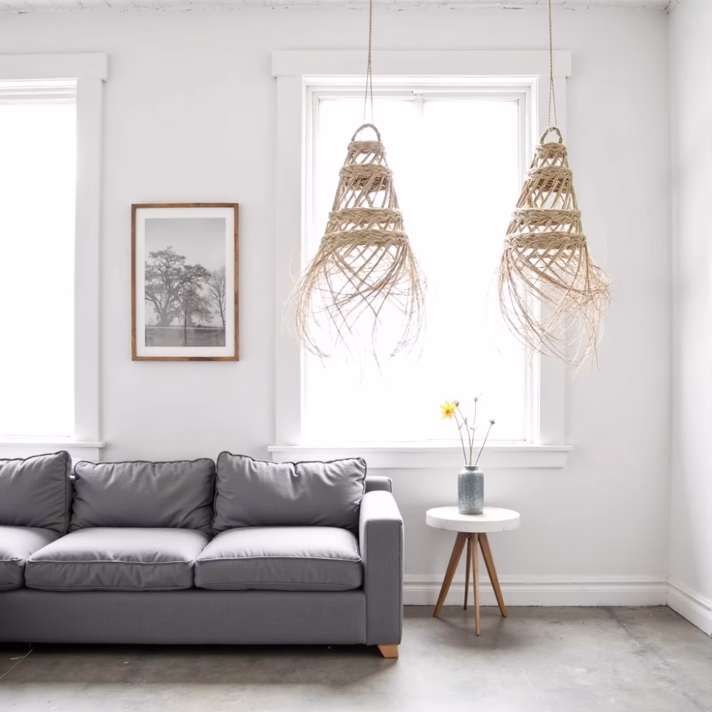 Straw hanging lights adding texture above gray sofa in bright living room