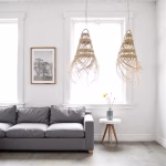 Straw hanging lights adding texture above gray sofa in bright living room