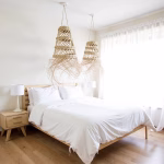 Pair of straw light shades creating warm ambiance in modern bedroom
