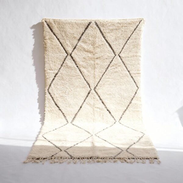 Traditional Moroccan carpet with diamond geometric pattern in cream wool with dark brown lines and fringed edges