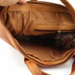 Top view of leather tote bag open showing zip closure and spacious interior compartment