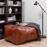 Leather rectangle ottoman 36 styled with reading materials in modern living room with industrial bookshelf
