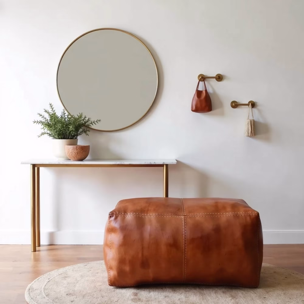 Brown leather rectangular ottoman pouf styled in minimalist entryway