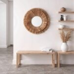 Natural raffia round mirror above minimalist console table with neutral decor in modern farmhouse interior