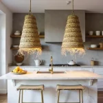 Pair of handwoven straw pendant lights illuminated over marble kitchen island with modern coastal decor