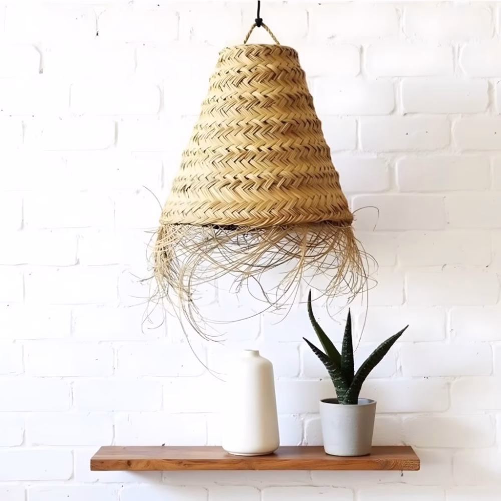 Single handwoven straw lamp against white brick wall with wooden shelf and plants